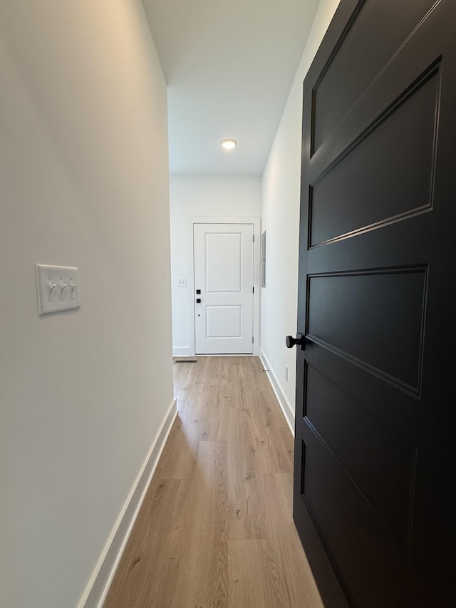 hallway featuring baseboards, light wood-style flooring, and recessed lighting
