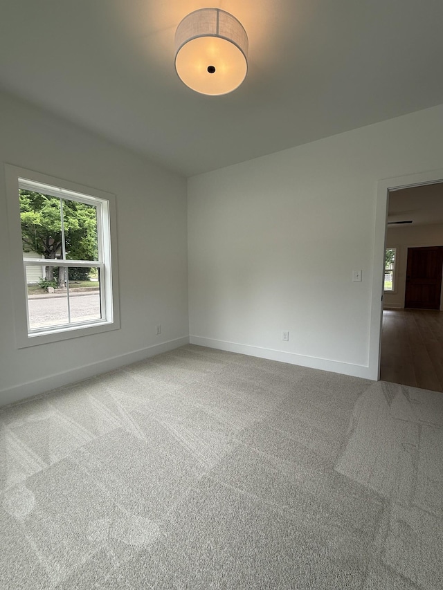 unfurnished room featuring carpet flooring and baseboards