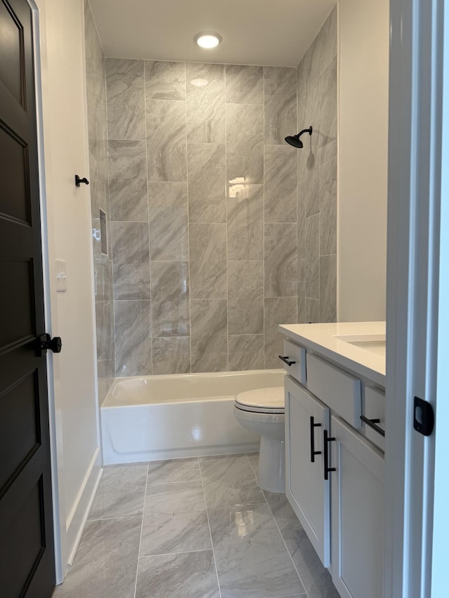 full bathroom with toilet, marble look tiles, vanity, shower / bathtub combination, and recessed lighting