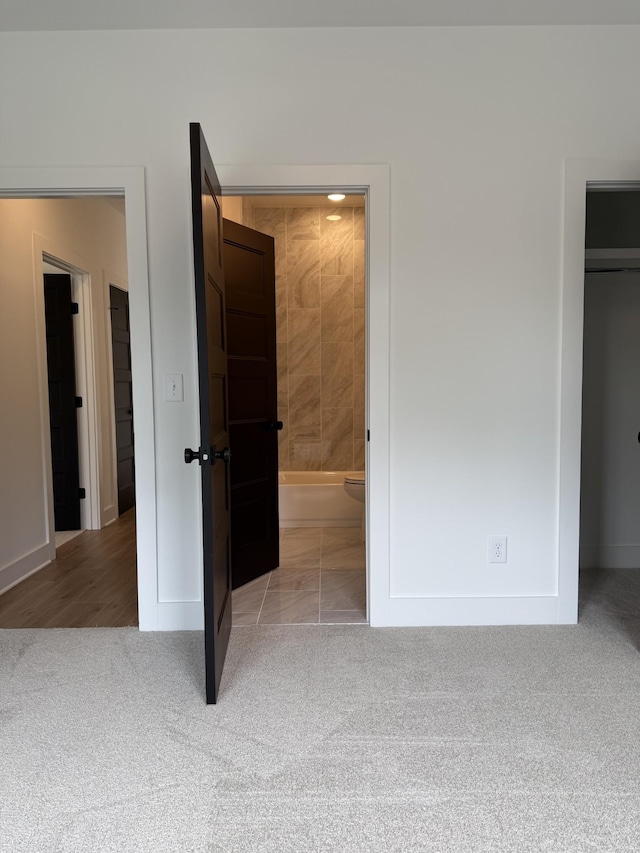 unfurnished bedroom featuring carpet, baseboards, and connected bathroom