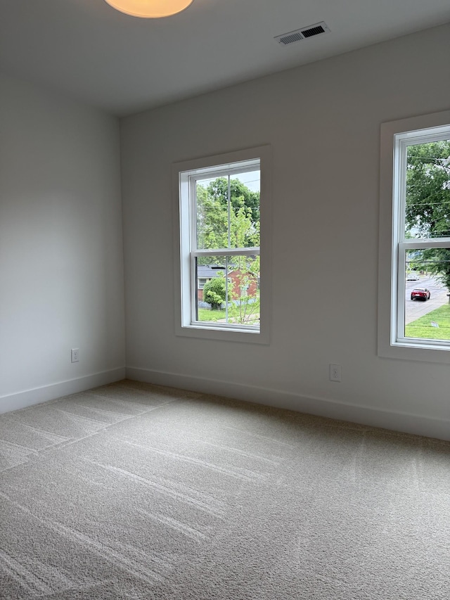 carpeted empty room featuring baseboards