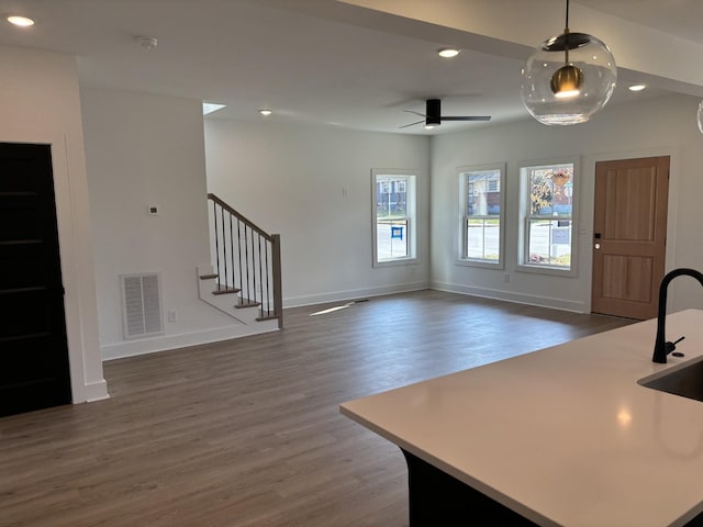 kitchen featuring recessed lighting, wood finished floors, baseboards, decorative light fixtures, and open floor plan