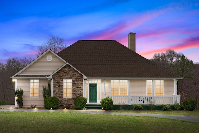 3337 Tarsus Rd, Palmyra, TN 37142 - view of front of home with a chimney, a front yard, stone siding, a porch, and roof with shingles