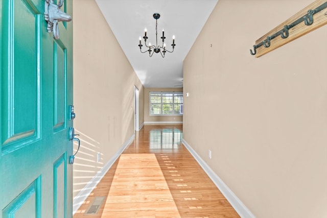 3337 Tarsus Rd, Palmyra, TN 37142 - corridor featuring a chandelier and light wood-style flooring