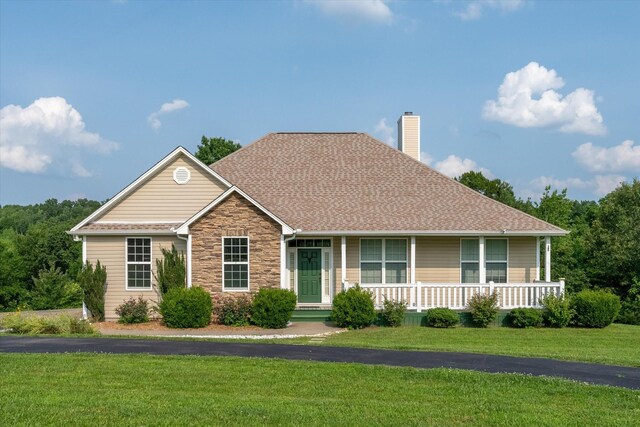 3337 Tarsus Rd, Palmyra, TN 37142 - view of front of home with a chimney, a front yard, stone siding, covered porch, and roof with shingles