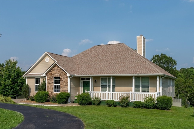 3337 Tarsus Rd, Palmyra, TN 37142 - view of front facade featuring a chimney, covered porch, a front yard, stone siding, and roof with shingles