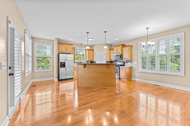 3337 Tarsus Rd, Palmyra, TN 37142 - kitchen with appliances with stainless steel finishes, a chandelier, a center island, light wood-style flooring, and light brown cabinets