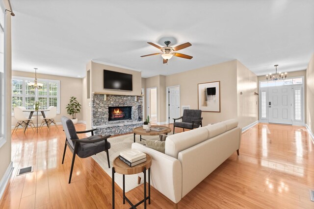 3337 Tarsus Rd, Palmyra, TN 37142 - living room with a chandelier, a fireplace, light wood-type flooring, and a ceiling fan