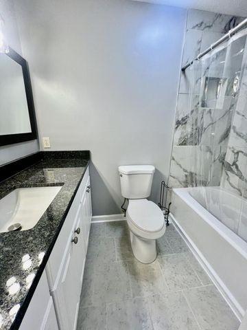 full bathroom with vanity, toilet, baseboards, and bathtub / shower combination