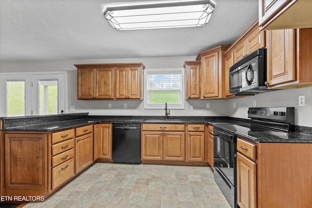 122 Springfield Ln, Jacksboro, TN 37757 - kitchen with black appliances, a peninsula, brown cabinets, a sink, and dark stone counters