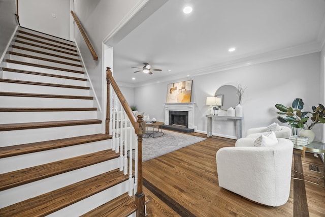 1183 Buckingham Cir, Franklin, TN 37064 - living area featuring ornamental molding, stairway, a ceiling fan, a fireplace with raised hearth, and recessed lighting