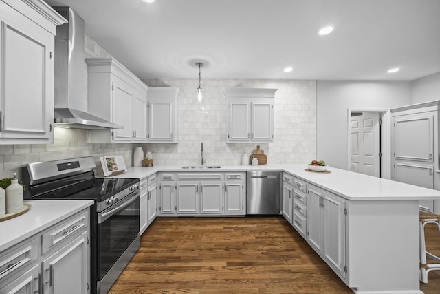 1183 Buckingham Cir, Franklin, TN 37064 - kitchen with stainless steel appliances, wall chimney range hood, a peninsula, a sink, and light countertops