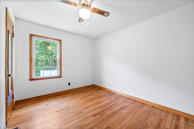 spare room with light wood finished floors, baseboards, and a ceiling fan