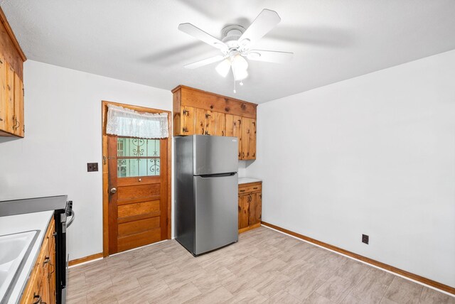 kitchen featuring stainless steel appliances, a ceiling fan, brown cabinets, and light floors