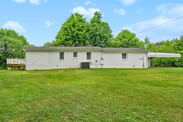 back of property with central air condition unit, a yard, a carport, and a wooden deck