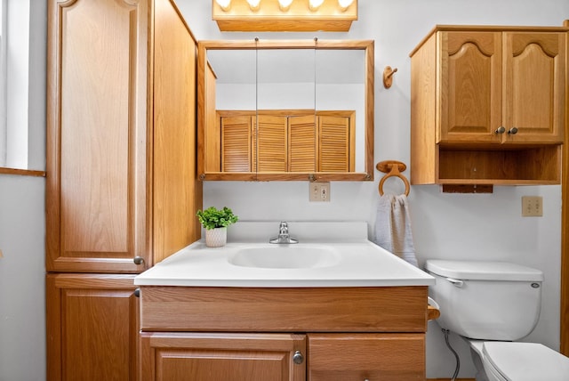 bathroom featuring toilet and vanity