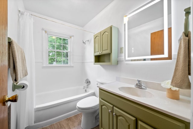 full bath featuring toilet, vanity, wood finished floors, tasteful backsplash, and washtub / shower combination