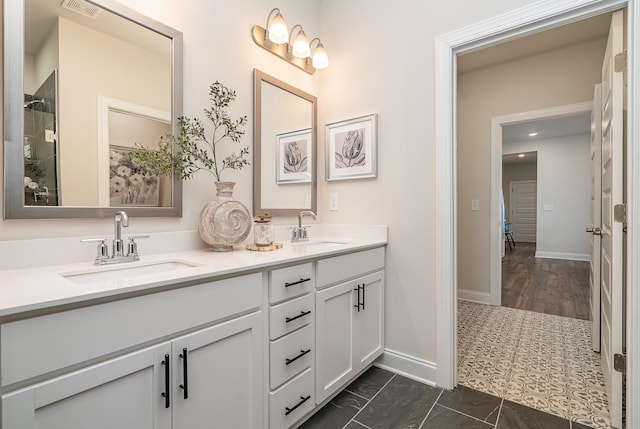full bathroom with double vanity and baseboards