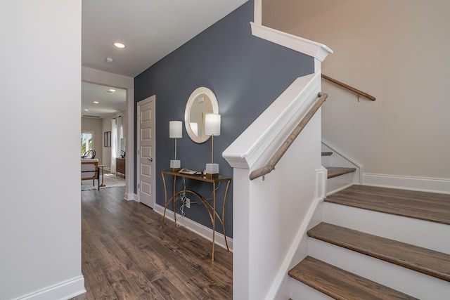 staircase featuring wood finished floors, baseboards, and recessed lighting