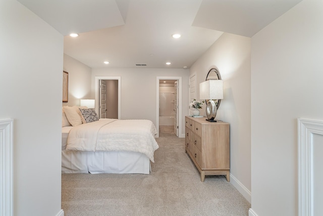 bedroom with light colored carpet, recessed lighting, baseboards, and connected bathroom
