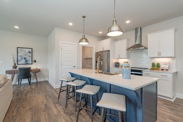 kitchen featuring wall chimney range hood, stainless steel appliances, dark wood finished floors, white cabinetry, and recessed lighting