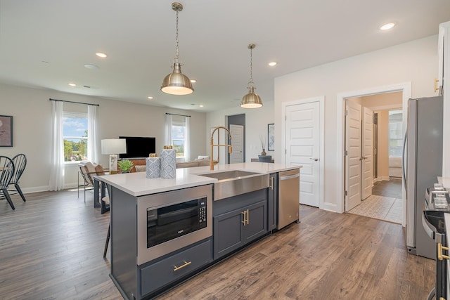 kitchen with a sink, stainless steel appliances, light countertops, plenty of natural light, and recessed lighting