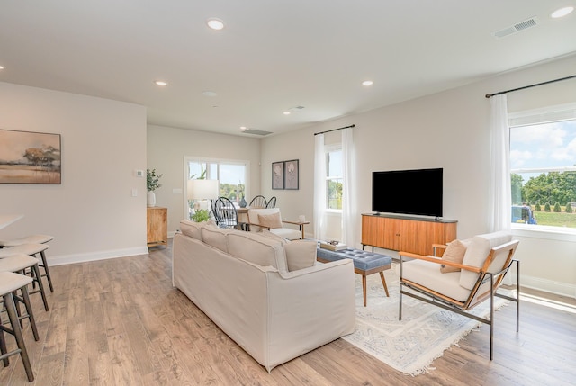 living area featuring light wood finished floors, baseboards, and recessed lighting