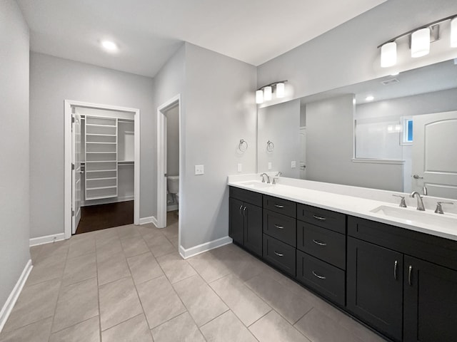 6332 York Dr, Hermitage, TN 37076 - bathroom featuring toilet, baseboards, double vanity, a spacious closet, and tile patterned floors