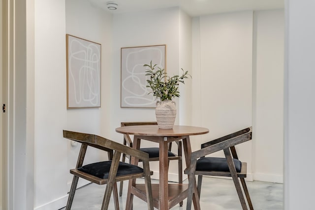 dining room featuring baseboards and concrete flooring