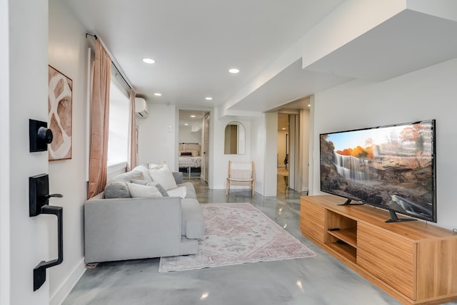 living room featuring finished concrete flooring, a wall mounted AC, and recessed lighting