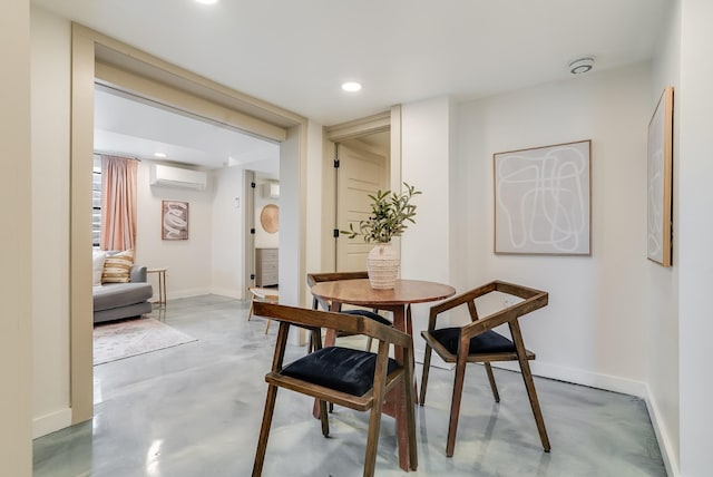 dining room with a wall unit AC, finished concrete flooring, recessed lighting, and baseboards