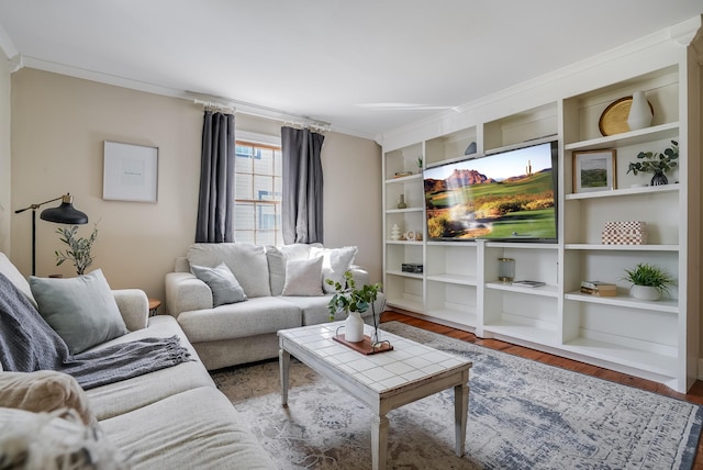living room with ornamental molding, wood finished floors, and built in shelves