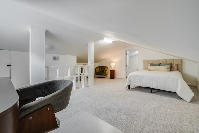 bedroom with vaulted ceiling, ornate columns, and carpet floors