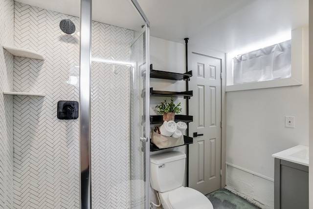 bathroom with a tile shower, vanity, and toilet
