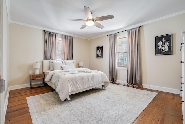 bedroom with crown molding, multiple windows, dark wood-type flooring, baseboards, and a ceiling fan