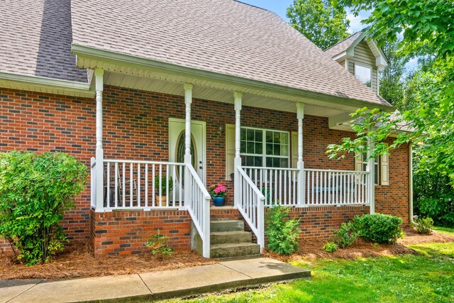 5643 Bethlehem Rd, Springfield, TN 37172 - doorway to property with roof with shingles, covered porch, and brick siding