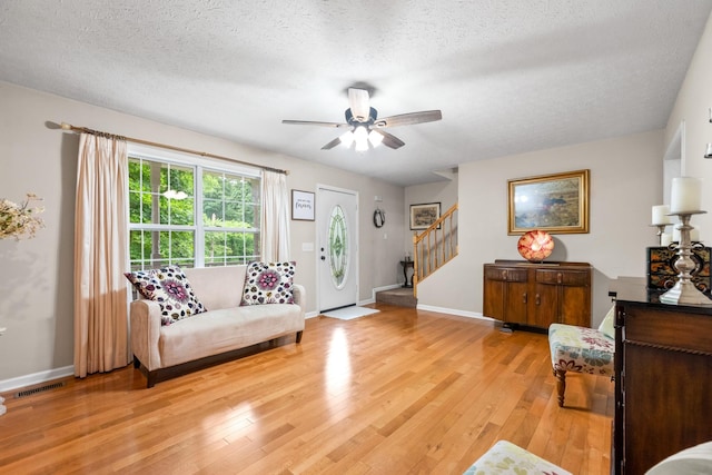 5643 Bethlehem Rd, Springfield, TN 37172 - living area featuring stairs, light wood-style floors, a textured ceiling, a ceiling fan, and baseboards