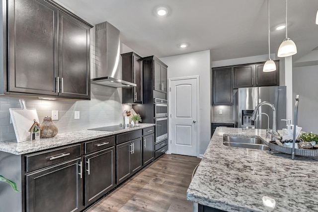 1044 Alta Vista Ln, Smyrna, TN 37167 - kitchen featuring wall chimney range hood, stainless steel appliances, a sink, dark wood-type flooring, and light stone counters