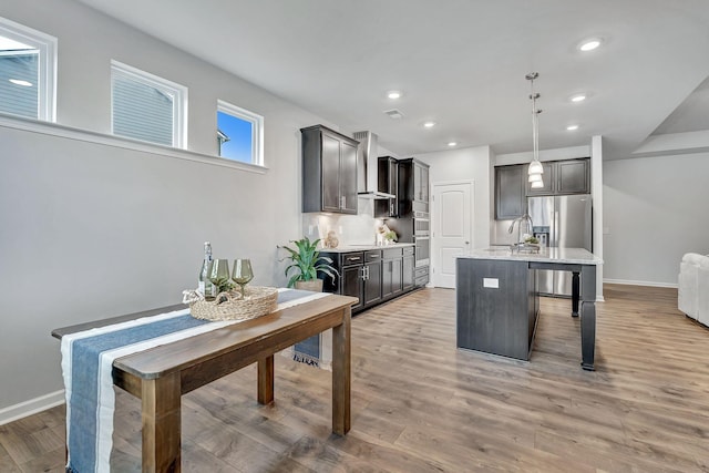 1044 Alta Vista Ln, Smyrna, TN 37167 - kitchen with light wood-style flooring, a kitchen island with sink, a kitchen bar, a sink, and recessed lighting