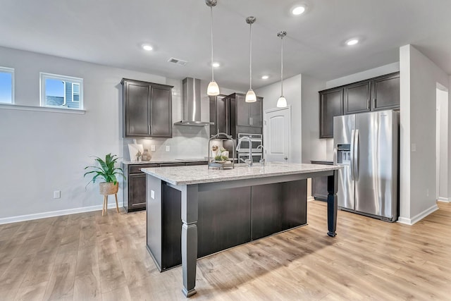 1044 Alta Vista Ln, Smyrna, TN 37167 - kitchen featuring stainless steel appliances, wall chimney exhaust hood, light wood-style floors, light stone countertops, and backsplash