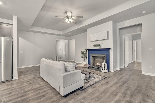 1044 Alta Vista Ln, Smyrna, TN 37167 - living area featuring ceiling fan, baseboards, a tray ceiling, and wood finished floors