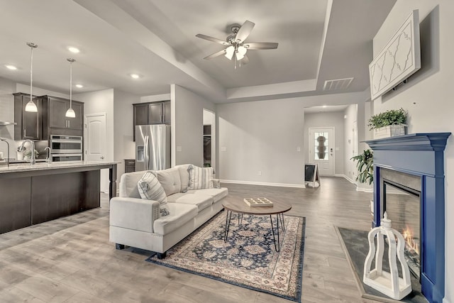 1044 Alta Vista Ln, Smyrna, TN 37167 - living room featuring a ceiling fan, a tray ceiling, baseboards, light wood-style flooring, and recessed lighting