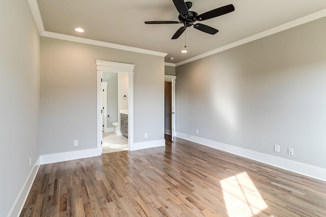 empty room with a ceiling fan, crown molding, wood finished floors, recessed lighting, and baseboards