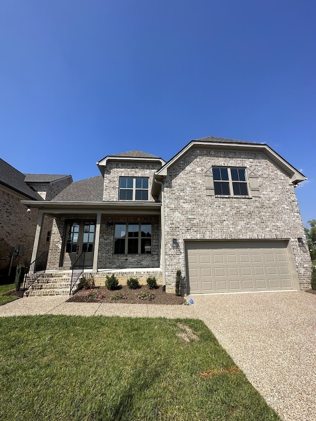 view of front facade featuring driveway, brick siding, a garage, a front lawn, and a porch