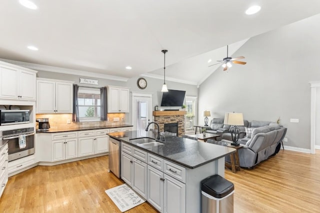 1384 Round Hill Ln, Spring Hill, TN 37174 - kitchen with stainless steel appliances, a sink, a fireplace, decorative backsplash, and ceiling fan