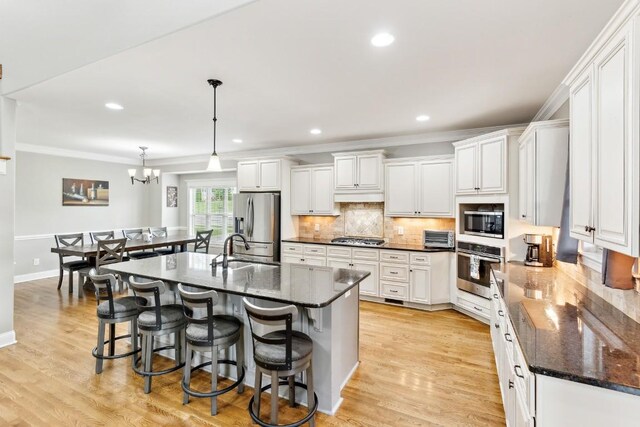 1384 Round Hill Ln, Spring Hill, TN 37174 - kitchen with appliances with stainless steel finishes, a sink, ornamental molding, under cabinet range hood, and decorative backsplash