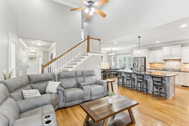 1384 Round Hill Ln, Spring Hill, TN 37174 - living room featuring crown molding, light wood-style floors, stairs, ceiling fan, and recessed lighting