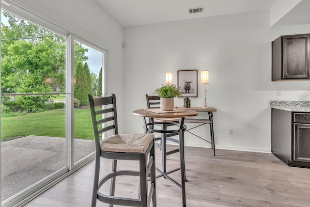 dining area featuring light wood finished floors and baseboards