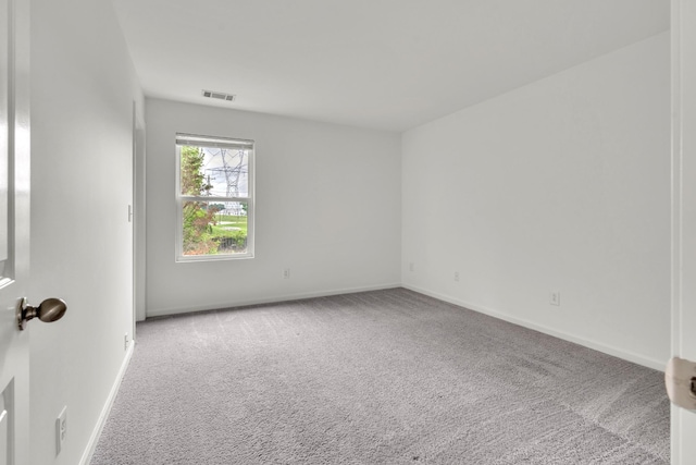 carpeted spare room featuring baseboards
