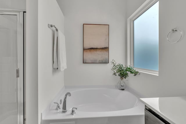 full bathroom featuring a garden tub, a stall shower, and vanity